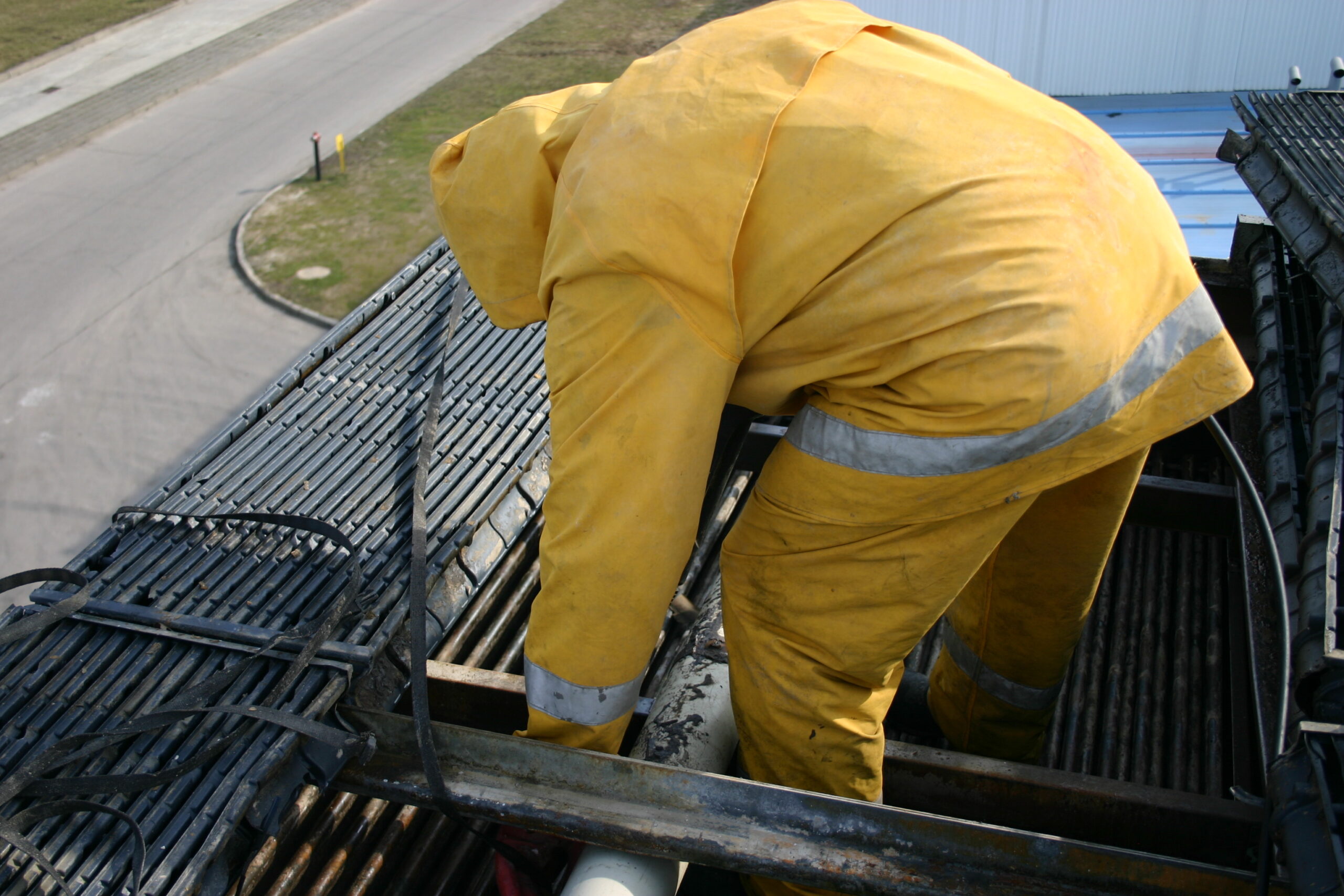 Pracownik na dachu, czyszczący skraplacz amoniakalny